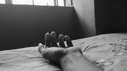 Cropped hand of person on bed