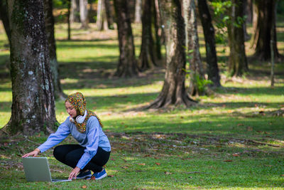 Young woman using laptop in park