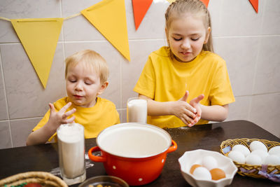 Kids prepare dough for holiday cupcake holiday easter, eggs on the table