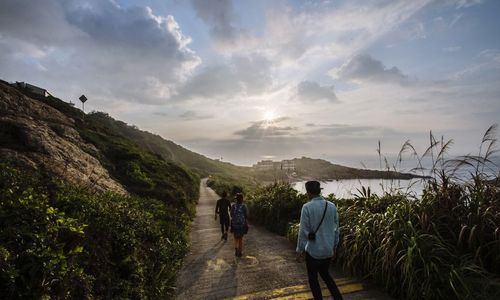 Rear view of woman walking on footpath