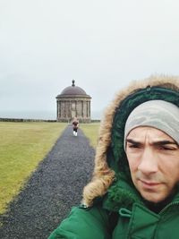 Portrait of man in park against sky during winter