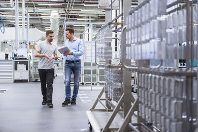 Two men with tablet talking about a product in factory shop floor