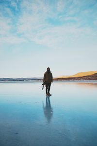 Full length of man standing on salt lake against sky