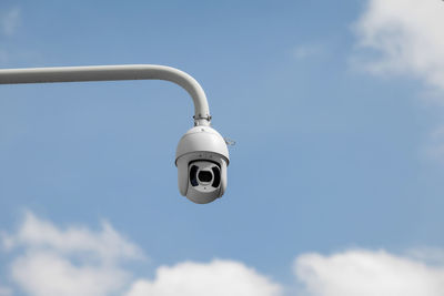 Low angle view of electric lamp against sky