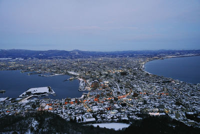 High angle view of townscape by sea against sky