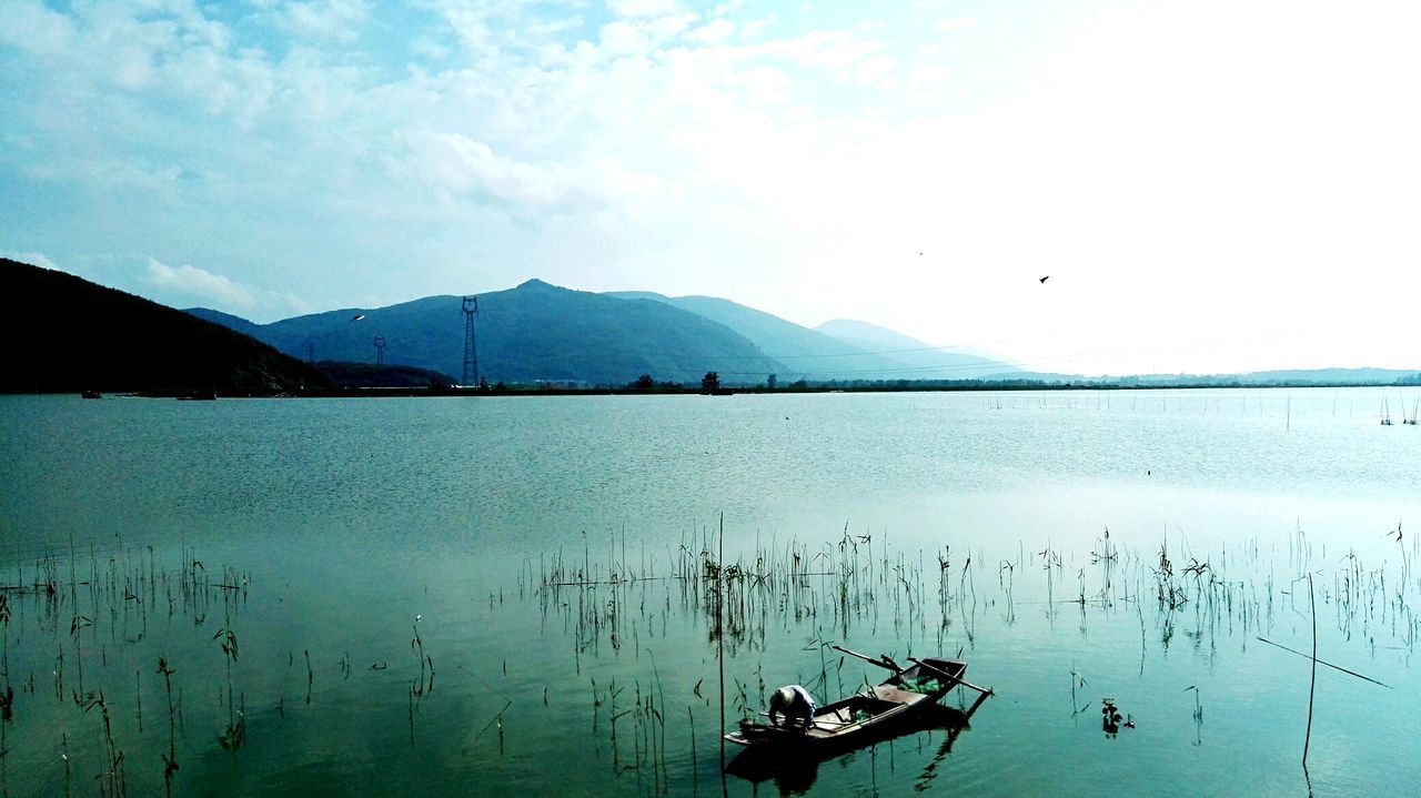 water, tranquil scene, sky, tranquility, mountain, lake, scenics, beauty in nature, nature, mountain range, idyllic, cloud - sky, non-urban scene, outdoors, day, cloud, calm, blue, remote, landscape, no people, weather, travel destinations