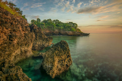 Scenic view of rocks in sea against sky