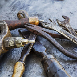 Close-up of various rusty tools on metal table