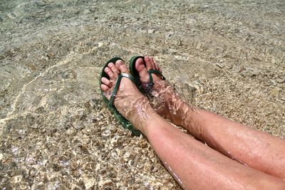 Low section of person relaxing on beach