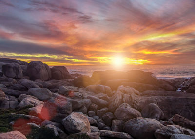 Rocks in sea during sunset