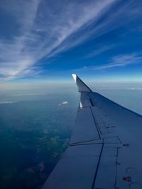 Airplane flying over clouds against blue sky
