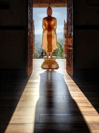 Sculpture of buddha statue on tiled floor in building