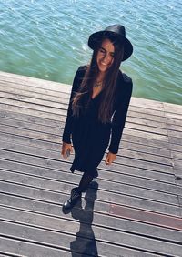 Full length of woman standing on pier over lake