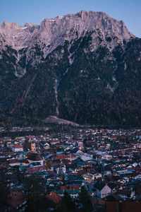 Aerial view of townscape by mountain against sky