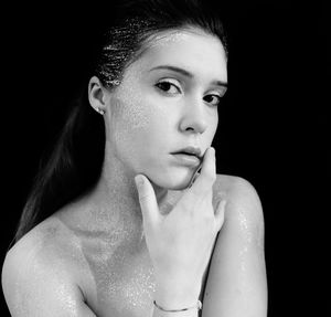 Portrait of a serious young woman over black background