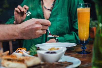 Midsection of man having drink on table