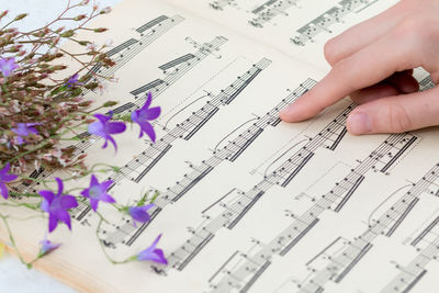 Cropped hand of woman touching sheet music