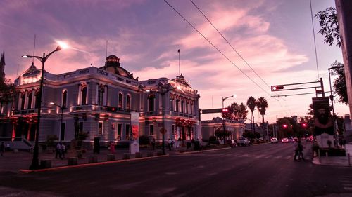 People walking on city street at sunset