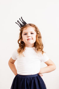 Portrait of cute girl standing against white background