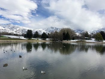 Scenic view of lake by snowcapped mountains against sky