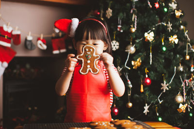 Girl with gingerbread cookie at home during christmas