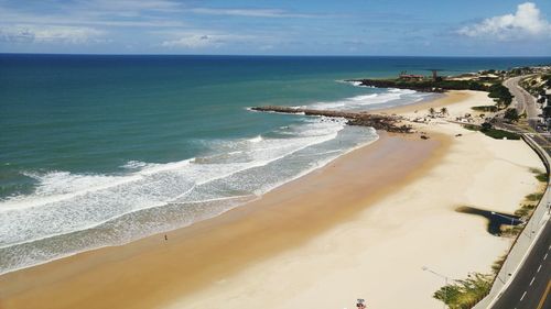 Scenic view of beach against cloudy sky