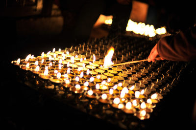 Illuminated candles burning in dark