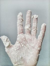 Close-up of dirty hand against wall