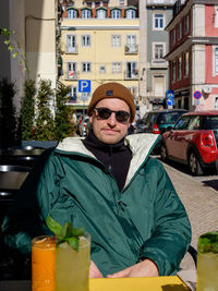 Portrait of young man sitting in city