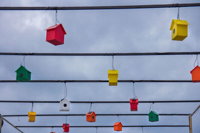 Low angle view of multi colored flags hanging against sky