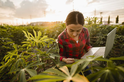 Woman looking at camera while sitting on field