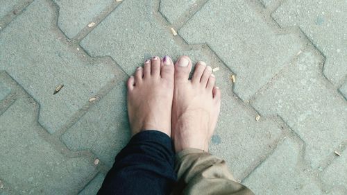 Low section of woman standing on footpath