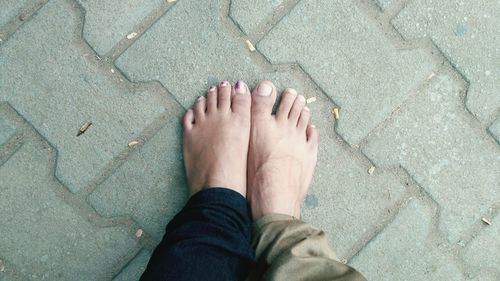 Low section of man and woman standing on footpath