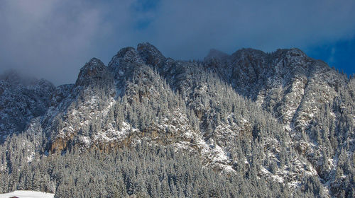 Low angle view of snowcapped mountains against sky