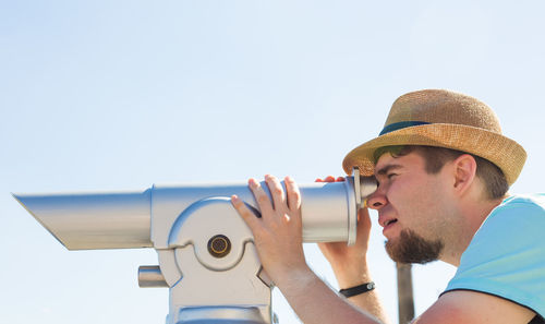 Portrait of young man looking at camera against sky