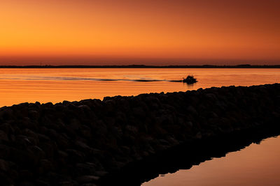 Scenic view of sea against romantic sky at sunset