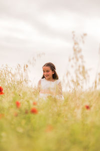 Portrait of young woman standing on field