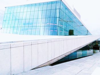 Reflection of building on swimming pool against sky