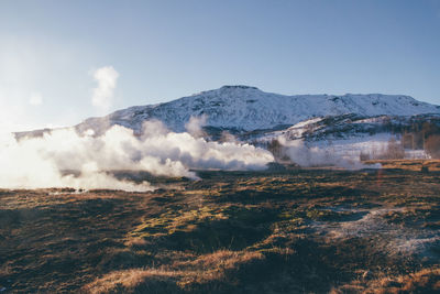 Scenic view of steam and mountain against sky