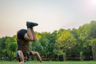 Rear view of man on field against sky