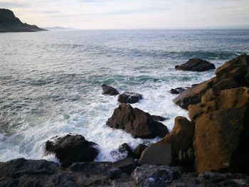 Scenic view of rocks in sea against sky