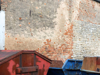 Garbage bins against brick wall