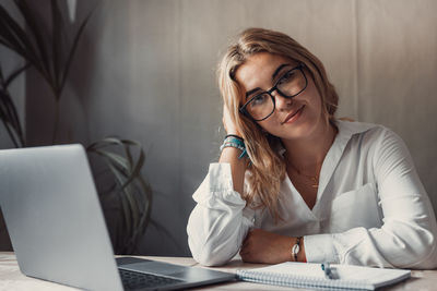 Young woman using mobile phone while sitting at home