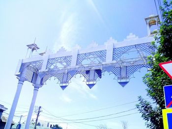 Low angle view of gate against cloudy sky