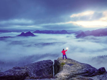 Man standing on rock against mountains