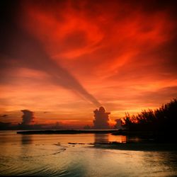 Scenic view of sea against cloudy sky at sunset