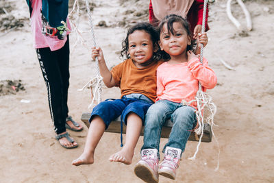 Full length of a smiling girl sitting outdoors