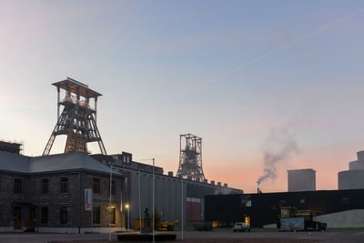 Factory against sky at sunset