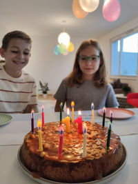 Smiling sibling celebrating birthday at home