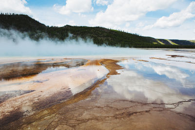 Scenic view of hot springs at yellowstone national park against cloudy sky